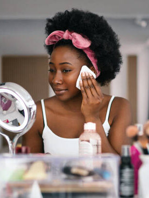 Beautiful woman cleaning her face with a face cloth.